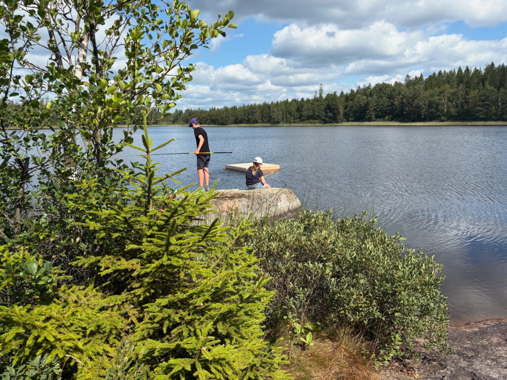 children fishing by lake